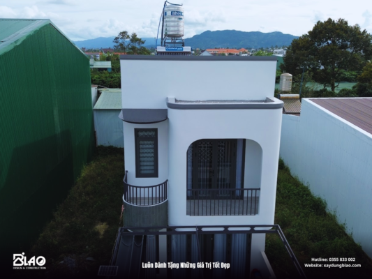 ngôi nhà phố hiện đại gây ấn tượng với những đường cong mềm mại trên mặt đứng, ban công xanh mát và gam màu trắng – xám nhã nhặn, tạo nên cảm giác thanh lịch, gần gũi